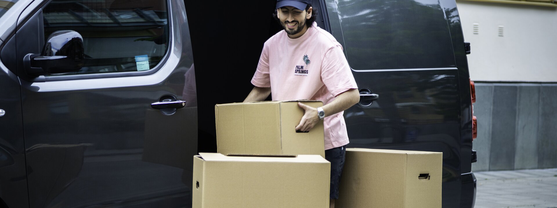 Mand som pakker en KINTO-bil med møbler 